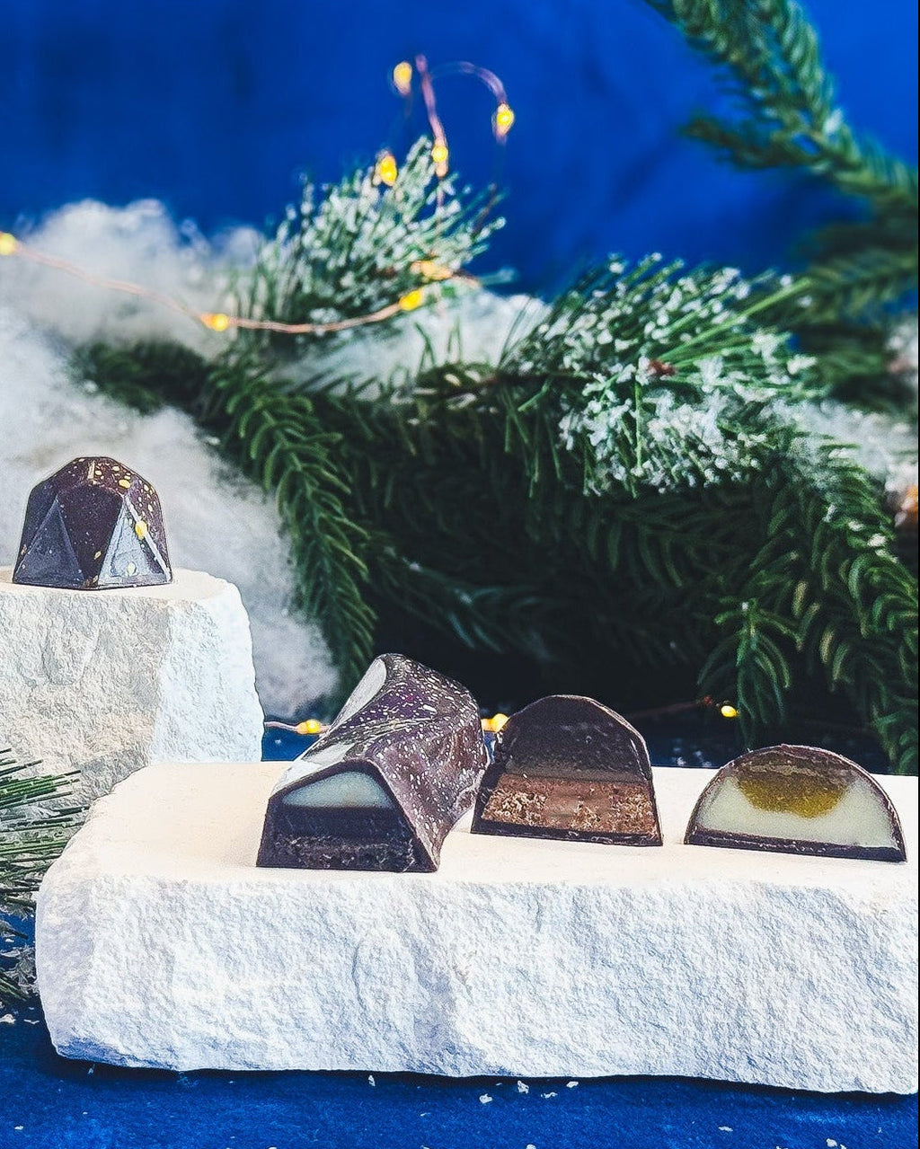 Chocolate pieces on a snowy landscape with Christmas trees and decorations.